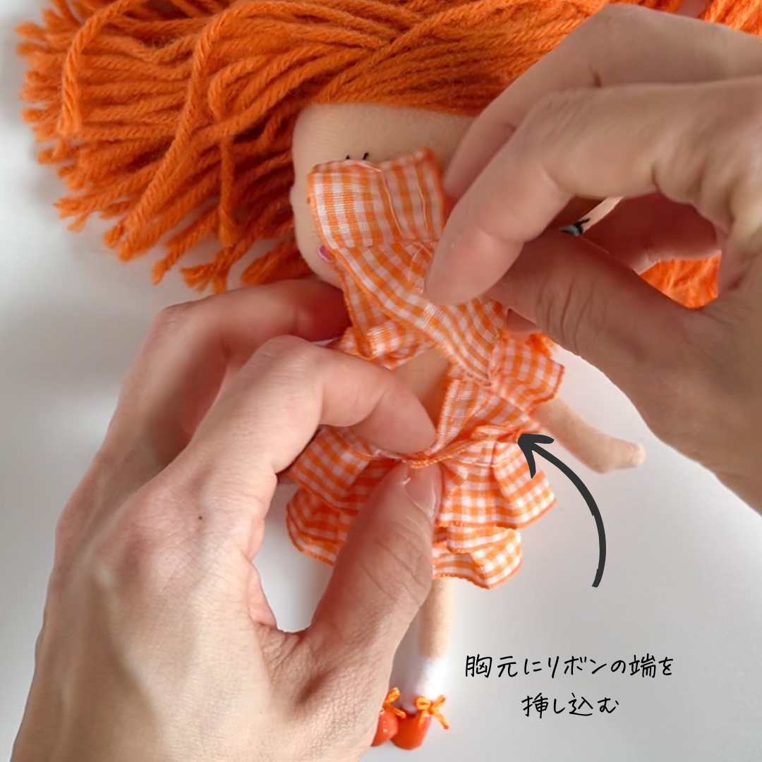 リボンの端を胸元に挿し込む